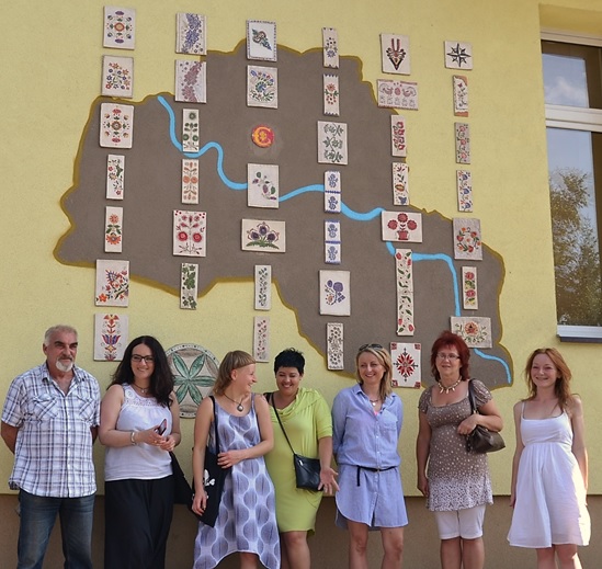 Uczestnicy warsztatów ceramicznych i ich mural "Skąd jesteśmy?" na ścianie naszego Centrum, lipiec 2015